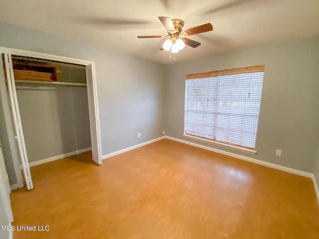 unfurnished bedroom featuring wood-type flooring, a closet, and ceiling fan