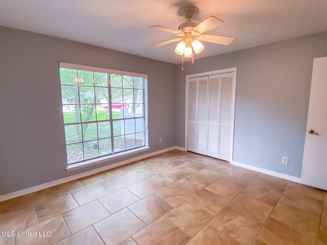 unfurnished bedroom with a closet, ceiling fan, and light tile patterned flooring