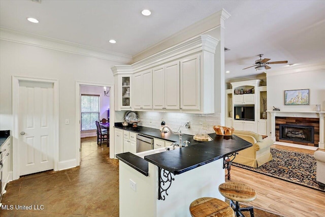 105 Speers Valley Rd, Brandon, MS 39042 - kitchen featuring a breakfast bar area, dark countertops, open floor plan, ornamental molding, and decorative backsplash