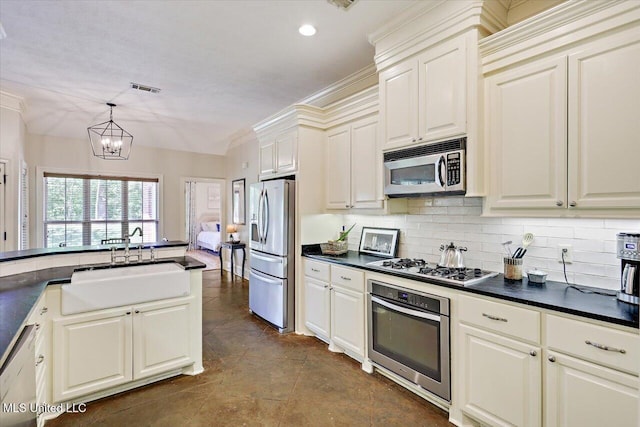 105 Speers Valley Rd, Brandon, MS 39042 - kitchen featuring appliances with stainless steel finishes, a sink, dark countertops, decorative backsplash, and a chandelier