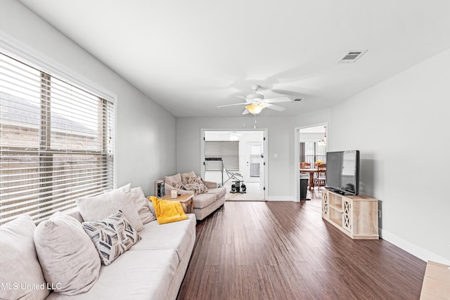 living room with dark hardwood / wood-style flooring and ceiling fan