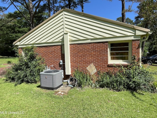2136 Attala Rd Unit 5247, Kosciusko, MS 39090 - view of side of property with central AC unit, brick siding, and a lawn