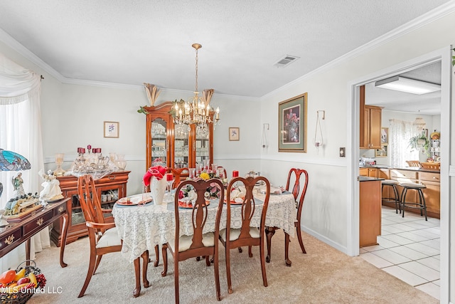 carpeted dining space with ornamental molding, a textured ceiling, and a notable chandelier