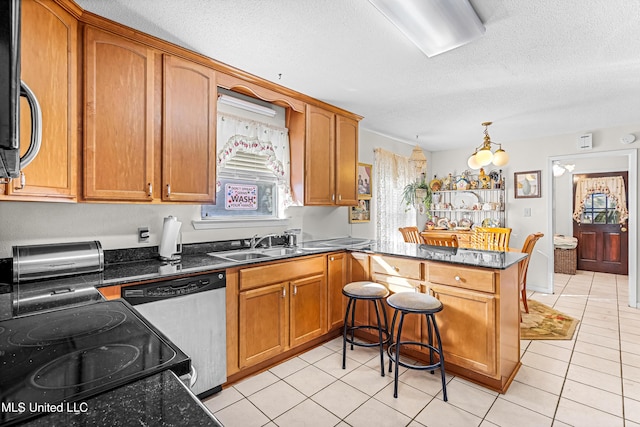 kitchen featuring kitchen peninsula, light tile patterned floors, stainless steel appliances, and a textured ceiling