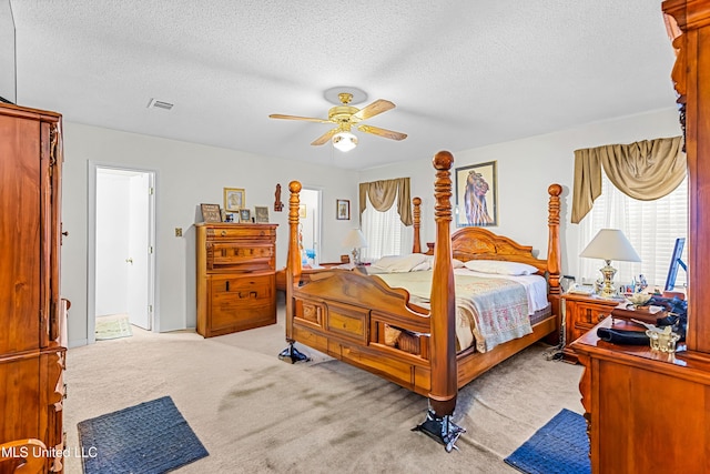 carpeted bedroom with a textured ceiling and ceiling fan