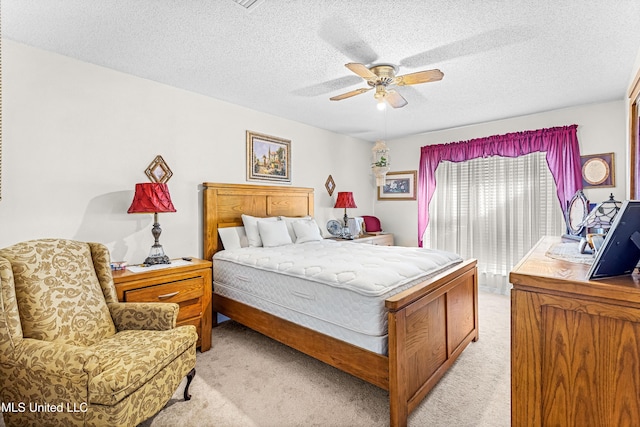 bedroom featuring a textured ceiling, ceiling fan, and light carpet