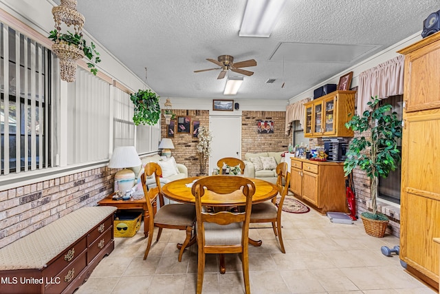 dining area with light tile patterned floors, a textured ceiling, ceiling fan, and brick wall