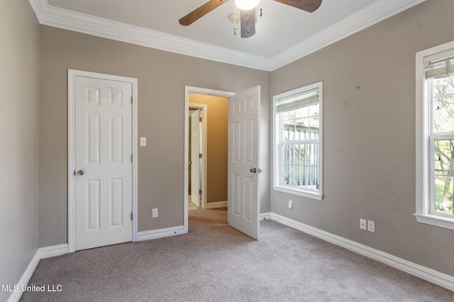 unfurnished bedroom with ornamental molding, multiple windows, and carpet flooring