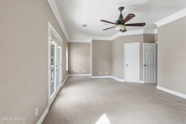 spare room featuring visible vents, baseboards, a ceiling fan, crown molding, and carpet flooring