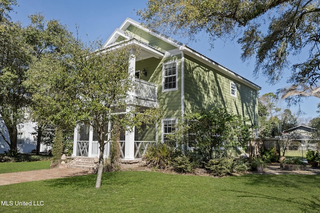 view of front of home featuring a balcony and a front lawn