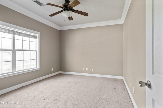 spare room featuring visible vents, baseboards, a ceiling fan, ornamental molding, and carpet