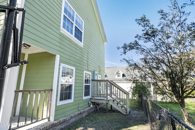 view of side of property featuring stairway and fence