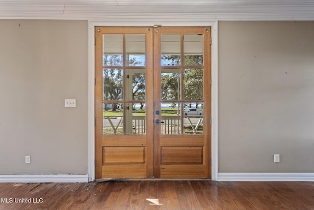 doorway with crown molding, baseboards, dark wood-style flooring, and french doors