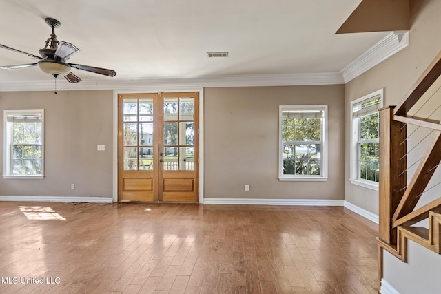 foyer with wood finished floors, visible vents, baseboards, french doors, and ornamental molding