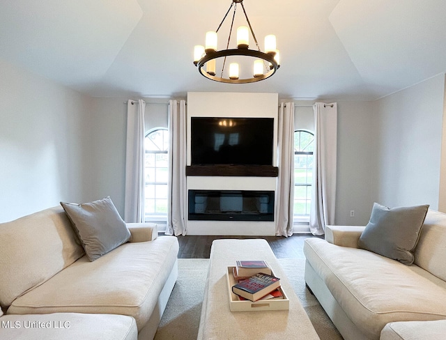 living room with wood-type flooring, lofted ceiling, and a chandelier