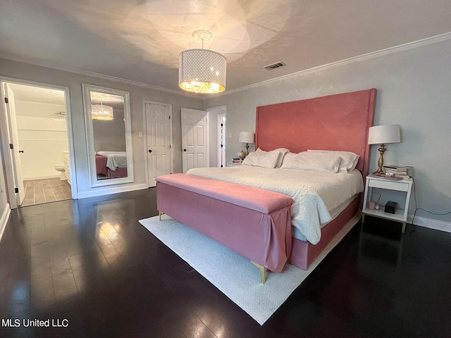 bedroom with crown molding, dark hardwood / wood-style floors, ensuite bathroom, and a chandelier