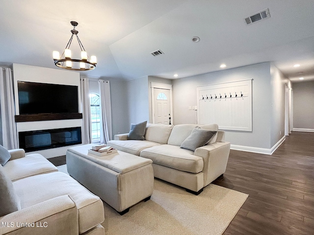 living room featuring lofted ceiling, hardwood / wood-style flooring, and a chandelier