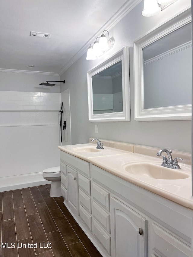 bathroom with toilet, crown molding, vanity, and a shower