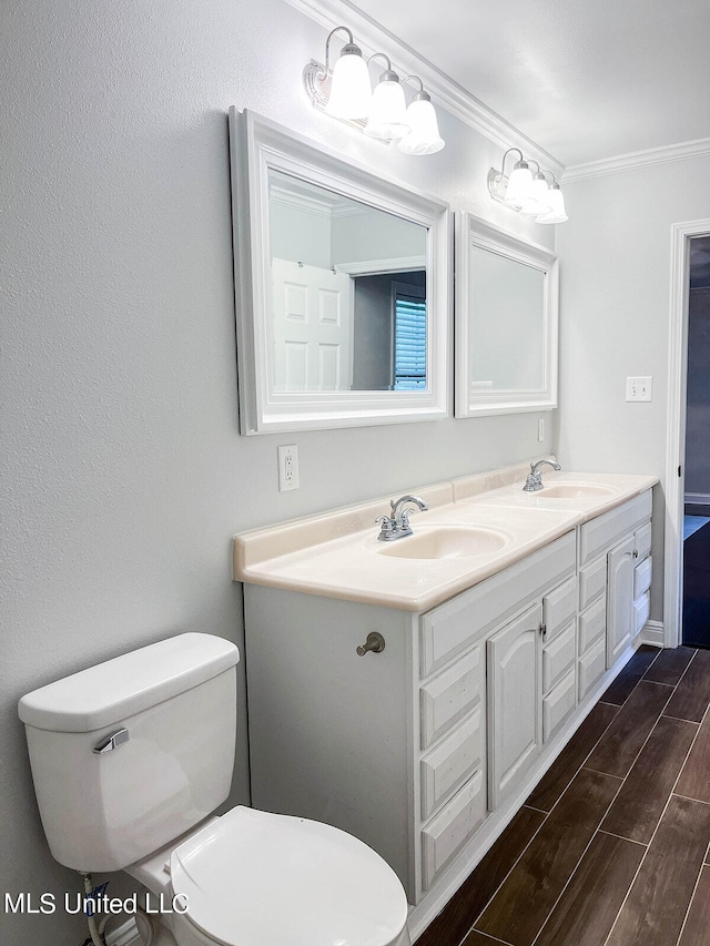 bathroom featuring vanity, wood-type flooring, ornamental molding, and toilet