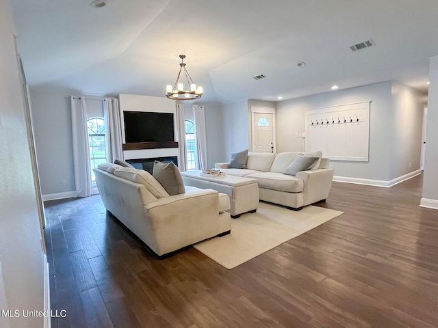 living room with lofted ceiling, dark wood-type flooring, and a notable chandelier