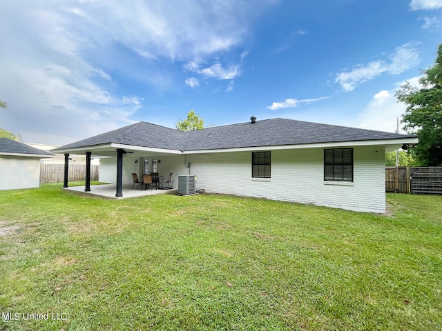 back of house featuring a patio area and a lawn