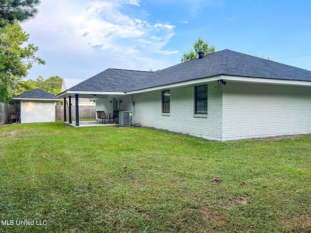 rear view of property featuring a patio area, a yard, and cooling unit