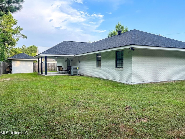 106 Piney Ridge Rd, Waveland, MS 39576 - back of house with fence, brick siding, central AC unit, a patio area, and a lawn
