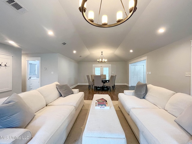 living room featuring lofted ceiling, a chandelier, and hardwood / wood-style floors