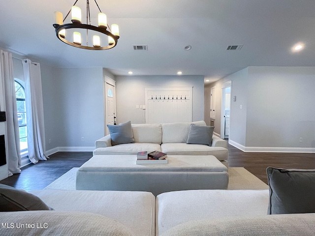 living room with an inviting chandelier and dark hardwood / wood-style flooring