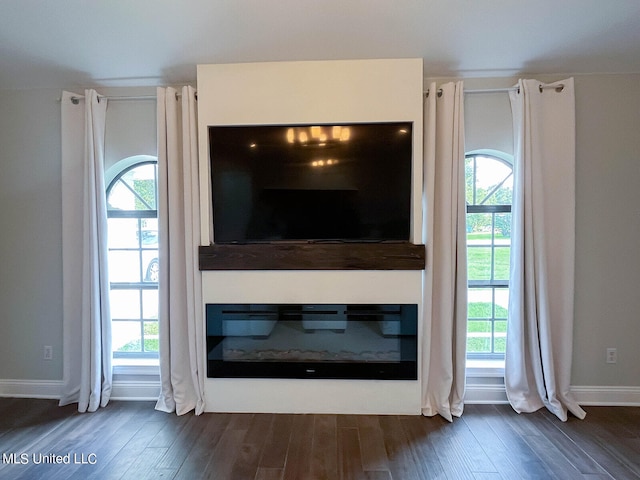 unfurnished living room with plenty of natural light and dark hardwood / wood-style floors