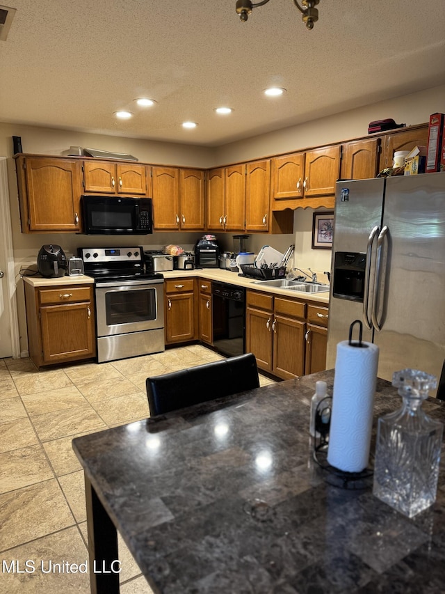 127 Nichols Blvd, Senatobia, MS 38668 - kitchen with black appliances, brown cabinets, recessed lighting, and a textured ceiling