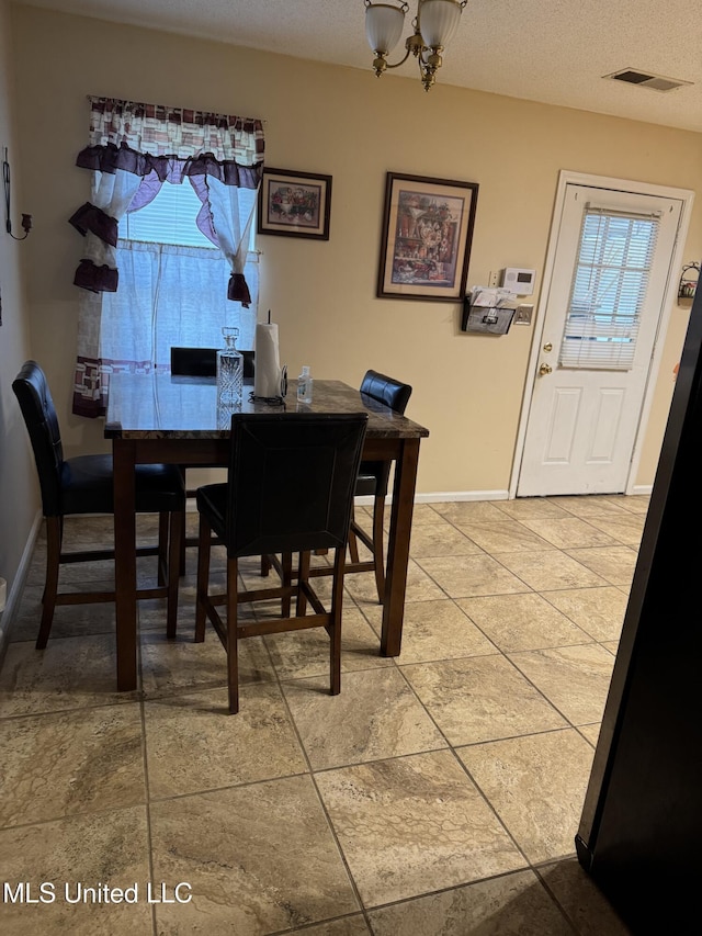 127 Nichols Blvd, Senatobia, MS 38668 - dining space featuring healthy amount of natural light, a chandelier, a textured ceiling, and light tile patterned floors