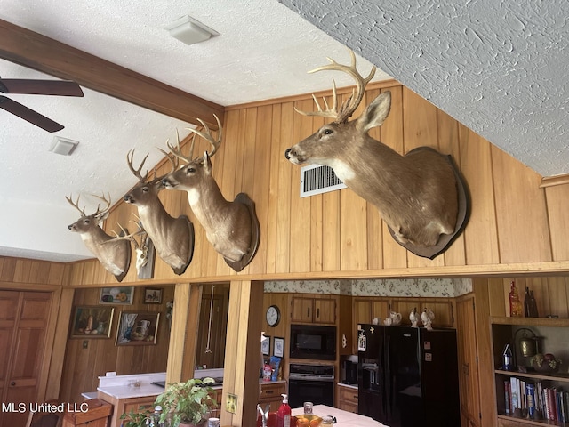13137 Old Port Gibson Rd, Utica, MS 39175 - interior details featuring wooden walls, a textured ceiling, and black appliances