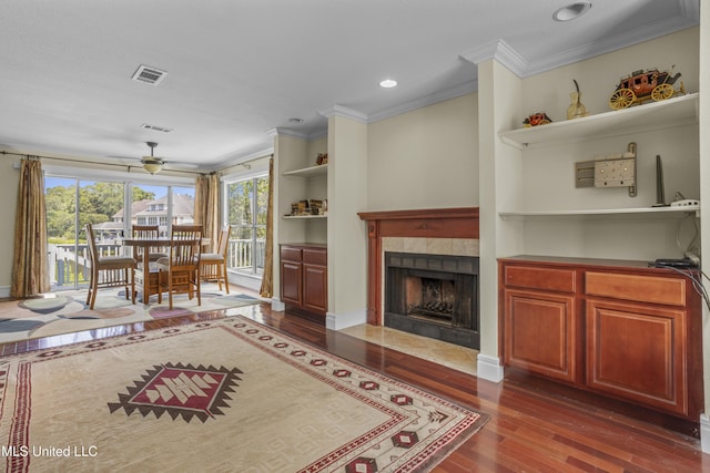 420 N Caribe Pl, Gulfport, MS 39507 - living room with dark wood-style floors, ceiling fan, crown molding, a tile fireplace, and built in features