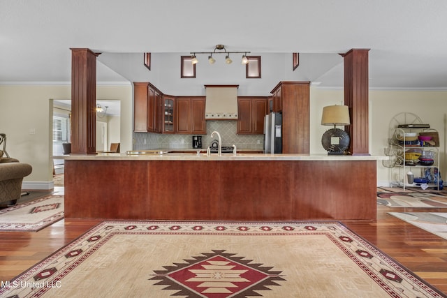 420 N Caribe Pl, Gulfport, MS 39507 - kitchen with light wood-style flooring, stainless steel fridge with ice dispenser, ornamental molding, glass insert cabinets, and a peninsula
