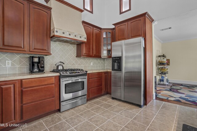 420 N Caribe Pl, Gulfport, MS 39507 - kitchen with appliances with stainless steel finishes, custom range hood, tasteful backsplash, glass insert cabinets, and crown molding