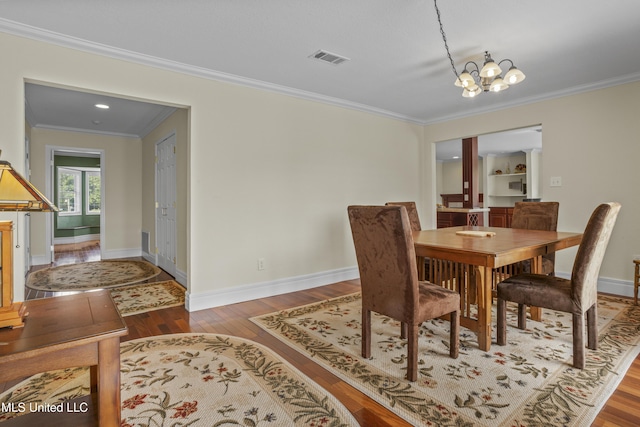 420 N Caribe Pl, Gulfport, MS 39507 - dining room with crown molding, wood finished floors, a chandelier, and baseboards