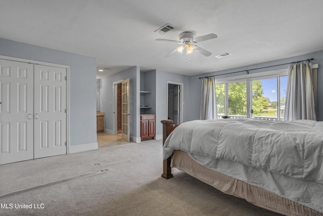 420 N Caribe Pl, Gulfport, MS 39507 - bedroom with light colored carpet, baseboards, ensuite bath, and a ceiling fan