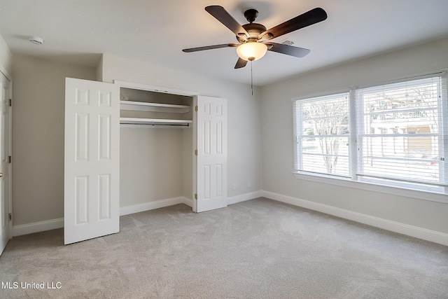 unfurnished bedroom featuring light carpet, a closet, and ceiling fan