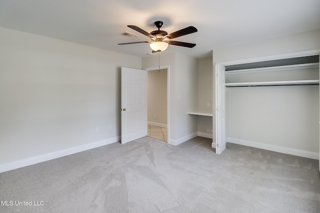 unfurnished bedroom featuring light colored carpet, a closet, and ceiling fan