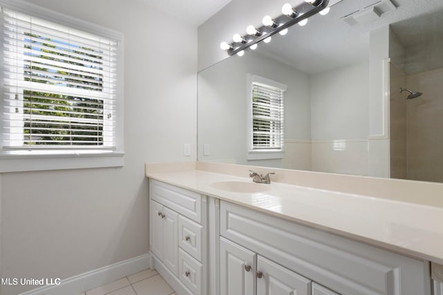 bathroom featuring tile patterned floors, vanity, and a shower