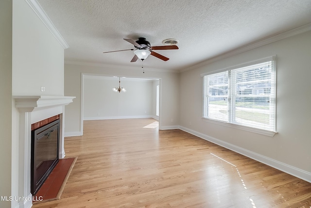 unfurnished living room featuring ceiling fan with notable chandelier, ornamental molding, light hardwood / wood-style floors, and a textured ceiling