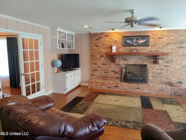 701 W Gresham St, Indianola, MS 38751 - living room featuring a textured ceiling, light hardwood / wood-style flooring, ornamental molding, and ceiling fan