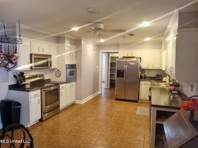 701 W Gresham St, Indianola, MS 38751 - kitchen with stainless steel appliances, sink, ornamental molding, ceiling fan, and white cabinetry