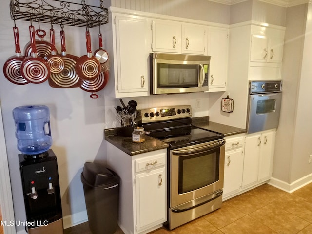 701 W Gresham St, Indianola, MS 38751 - kitchen with white cabinetry, stainless steel appliances, ornamental molding, and light tile patterned floors