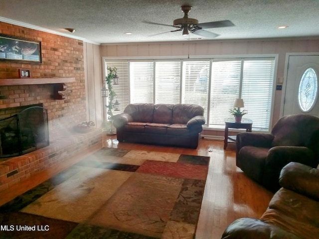 701 W Gresham St, Indianola, MS 38751 - living room with light hardwood / wood-style floors, ornamental molding, ceiling fan, a textured ceiling, and a fireplace
