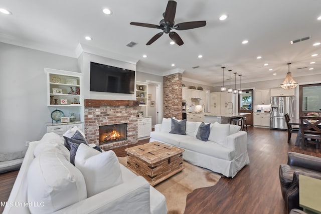 802 Old Spanish Trl, Bay Saint Louis, MS 39520 - living area with ornamental molding, ceiling fan, dark wood-style flooring, a brick fireplace, and recessed lighting