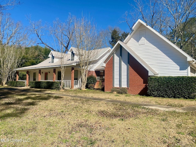 view of front of house featuring brick siding, a porch, and a front yard