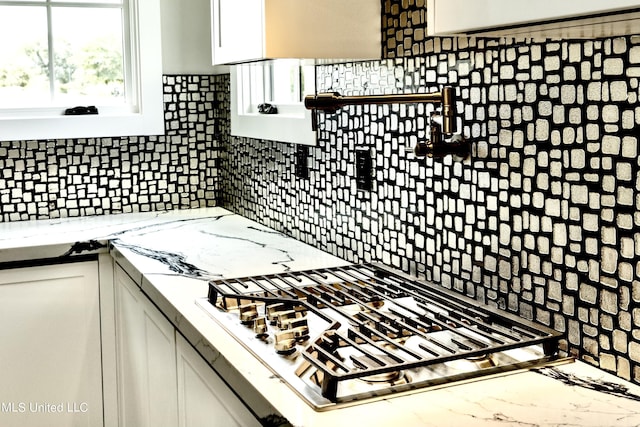138 Genoa Dr, Madison, MS 39110 - kitchen featuring stainless steel gas cooktop, white cabinetry, decorative backsplash, and light stone countertops