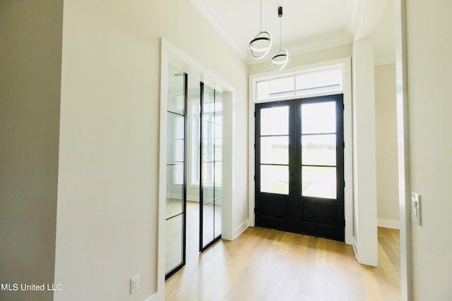 entryway featuring french doors, crown molding, and light wood-type flooring